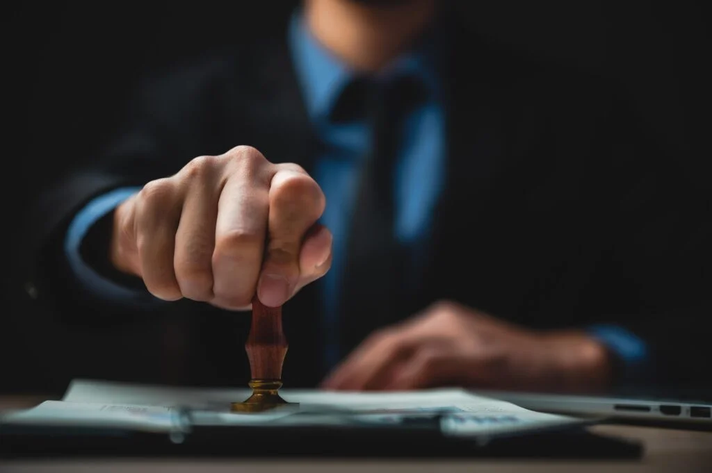 mobile notary public: Man holding a notary stamp press on a document